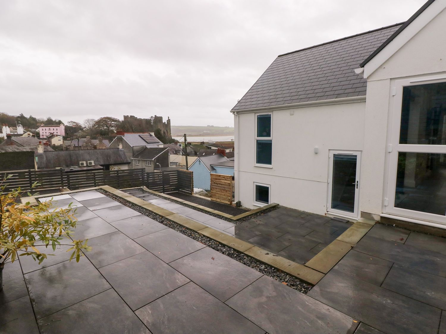 An outdoor space with slate paving and a wooden fence at Cottage 1 Laugharne