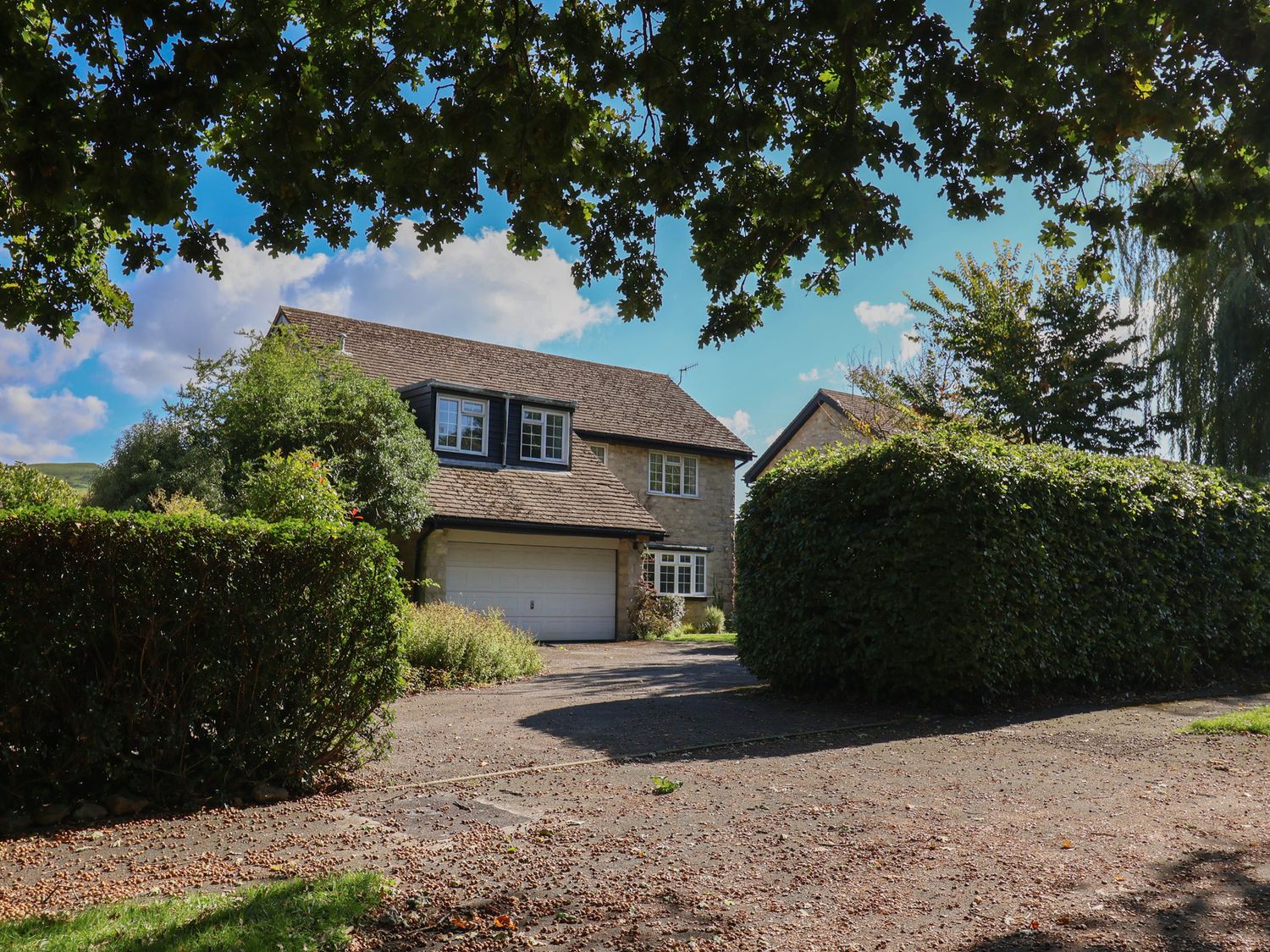 A house with a garage and bushes at Oakwood in Chideock