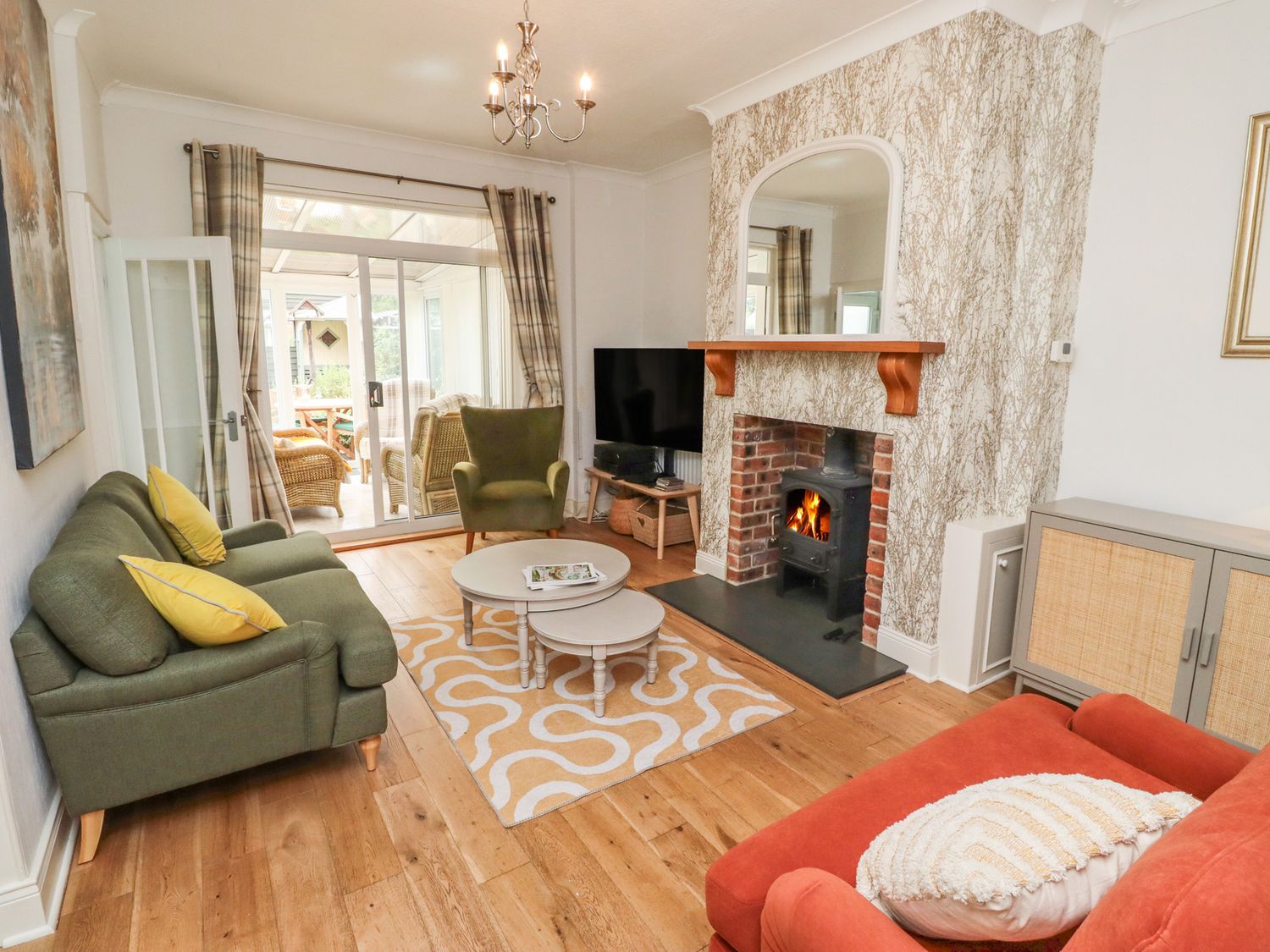 A living room with a sofa, armchair, coffee table, and fireplace at 5 Jackson Terrace, Morpeth