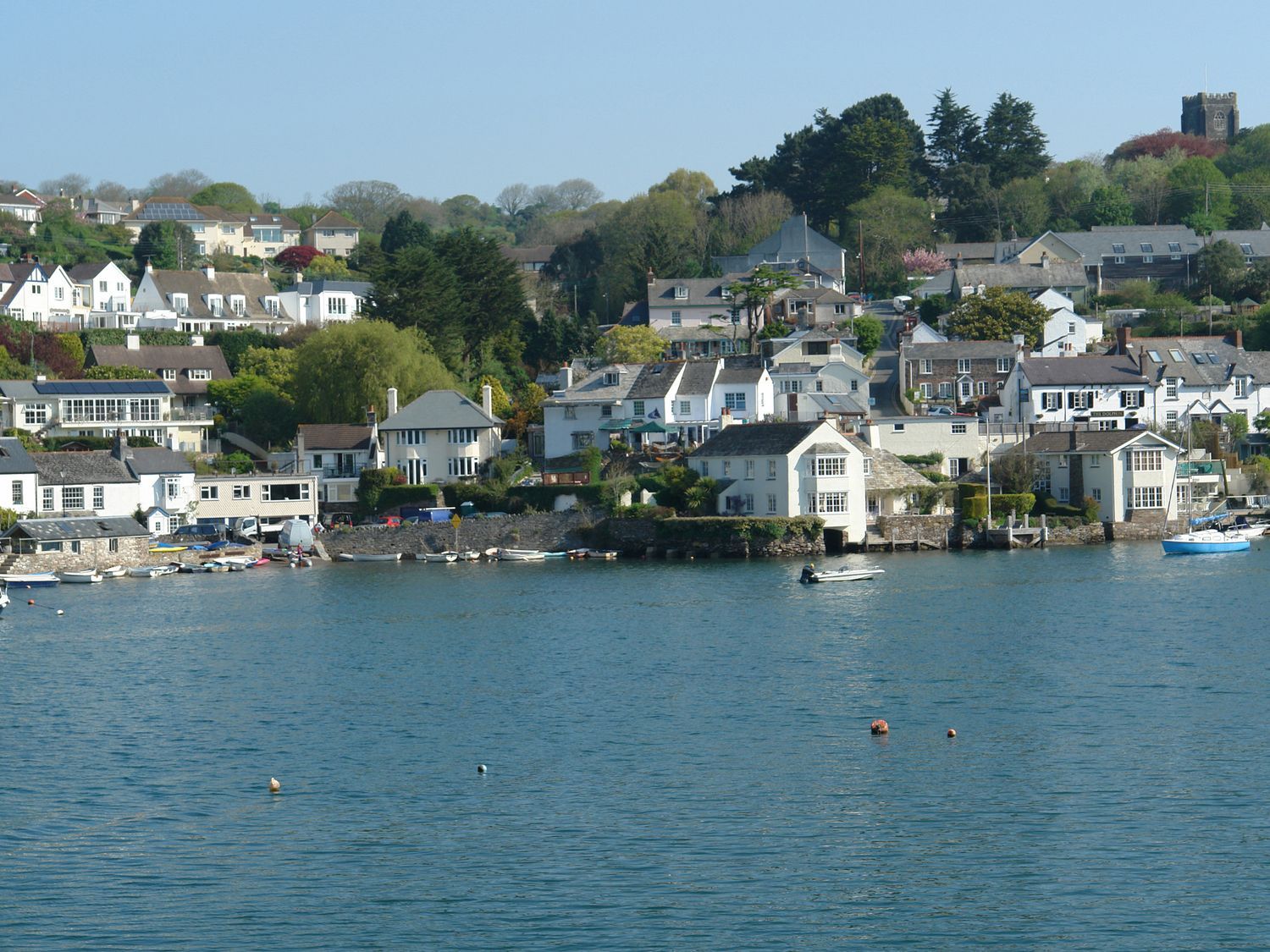 A view of houses and boats by the water at The Porthole in Newton Ferrers