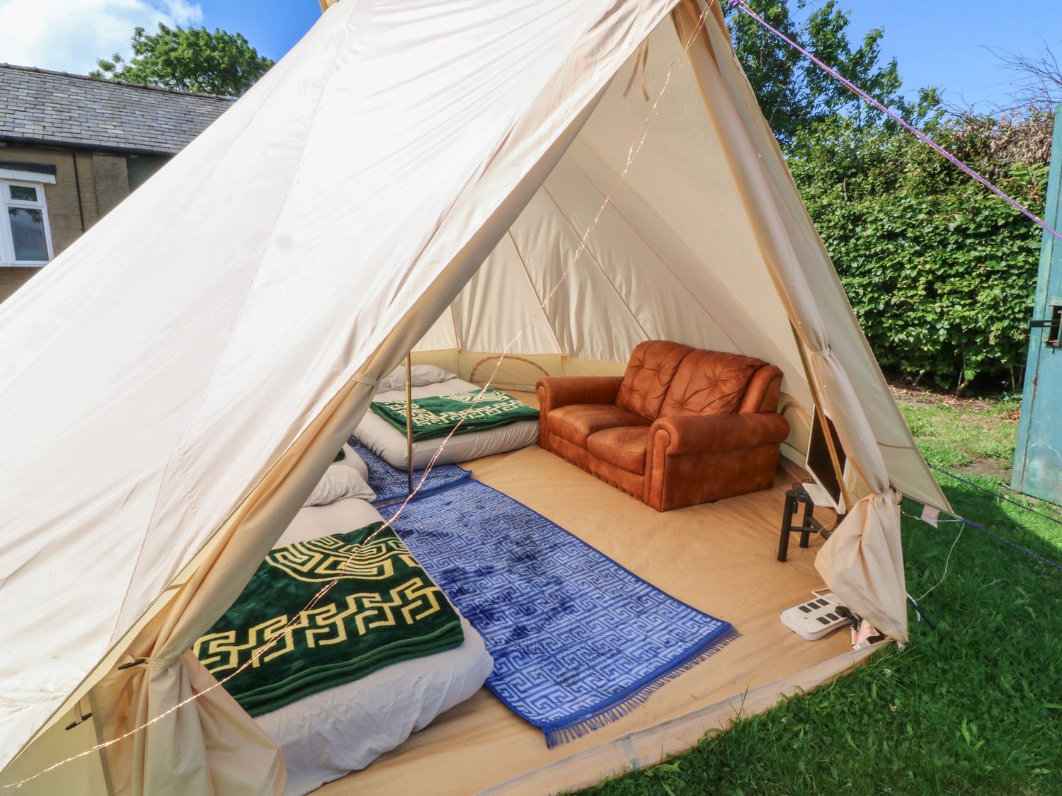 A tent with a sofa and beds at Bell Tent Three
