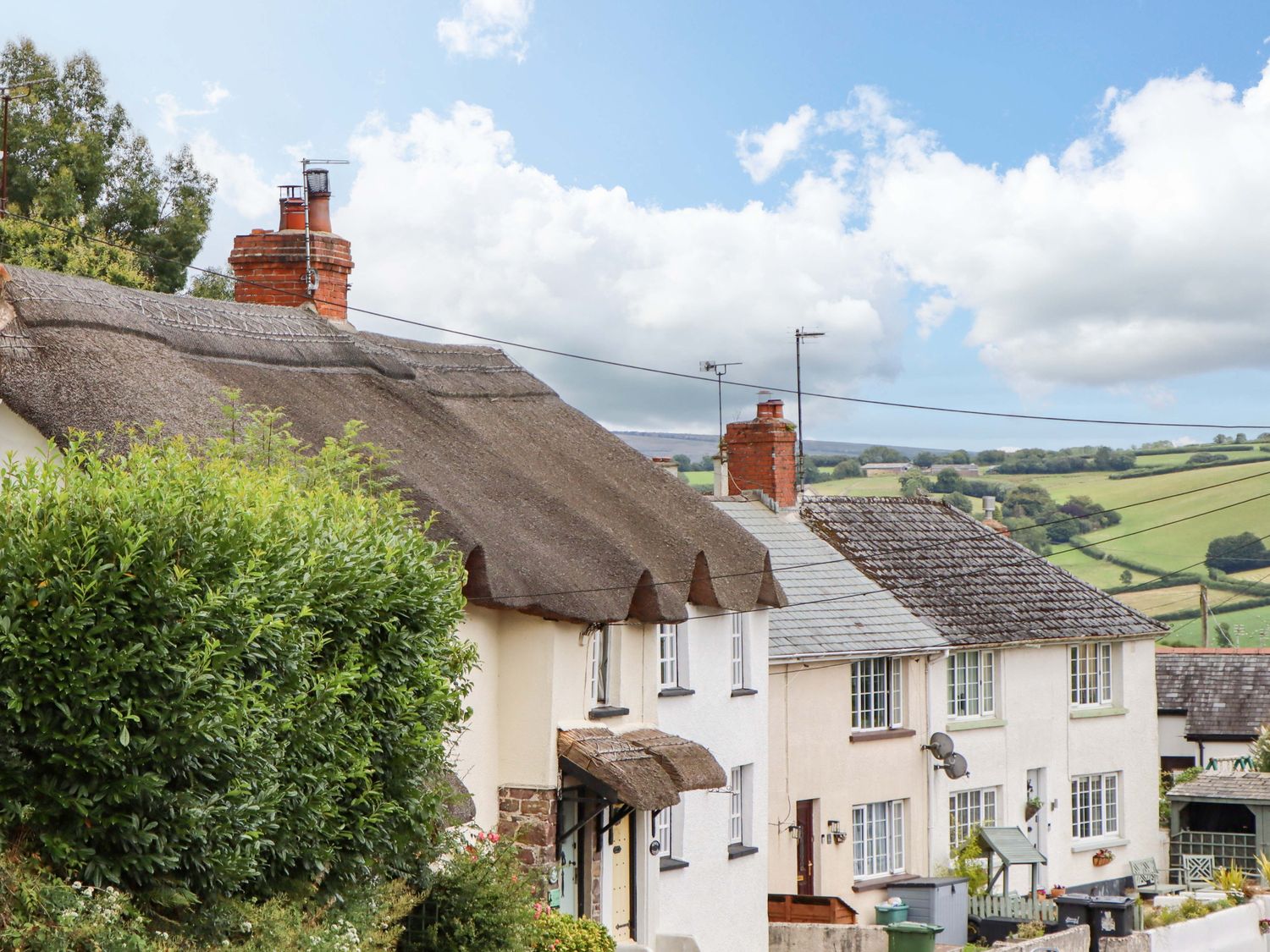 A view of cottages with thatched roofs in the countryside at Cosy Nook South Molton