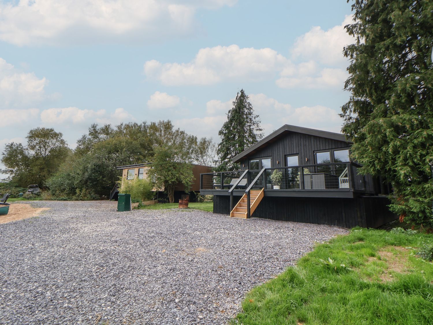 A house with a deck and steps in a garden at The Larch House in Farndon