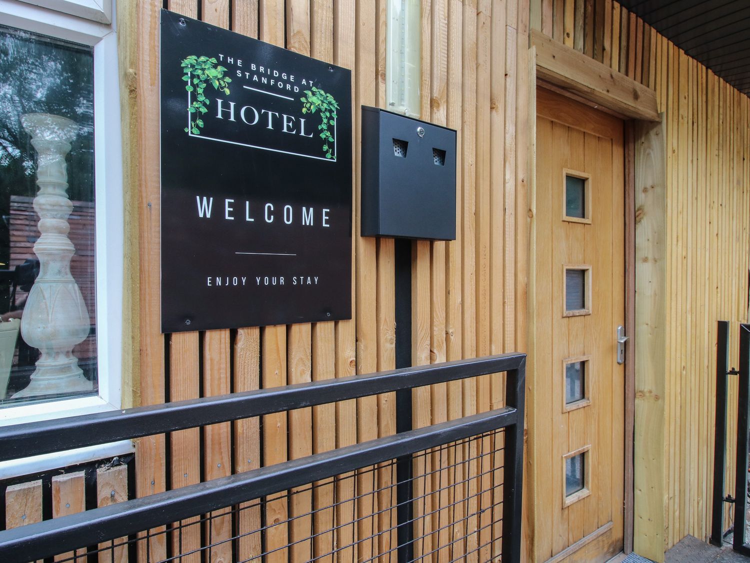 An entrance with a welcome sign and door at Apartment 1 The Bridge at Stanford Hotel near Great Witley