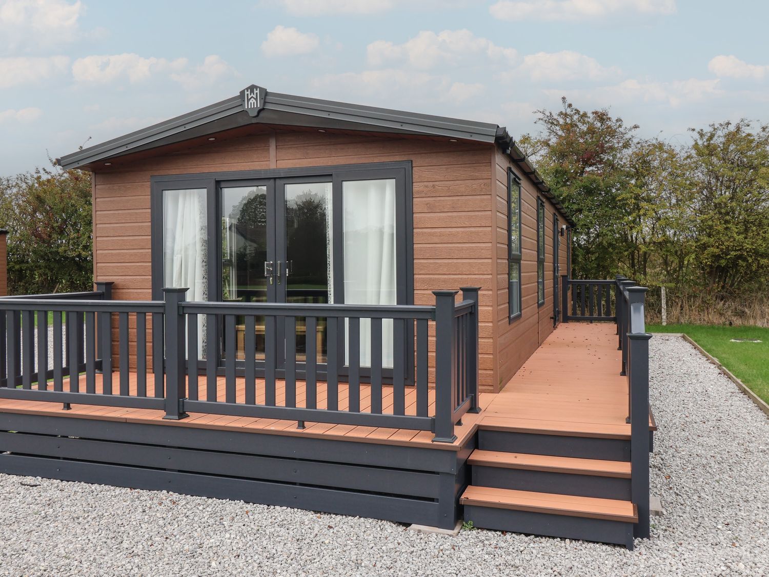 A wooden cabin with a deck and steps at Meadows Park 2 Great Hatfield near Hornsea