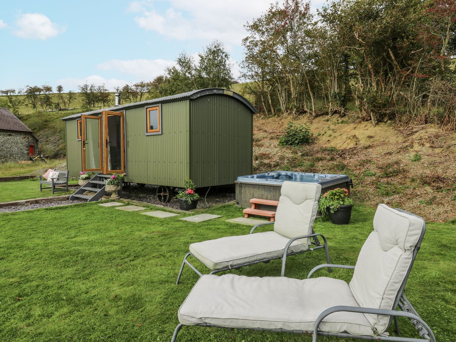A garden with a shepherd's hut and hot tub at Brondel Luxury Shepherd's Hut in 
