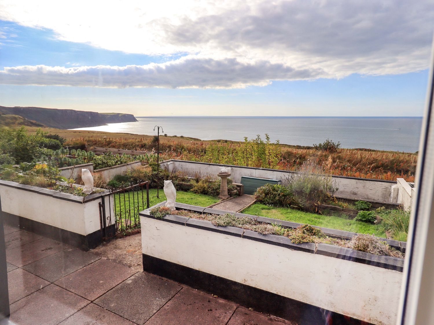An outdoor view of a garden overlooking the ocean at Solway View in Whitehaven