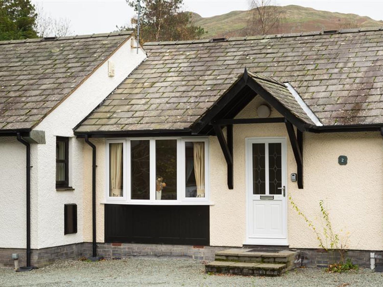 An entrance with a door and window at 2 Riverside Cottages in Ambleside