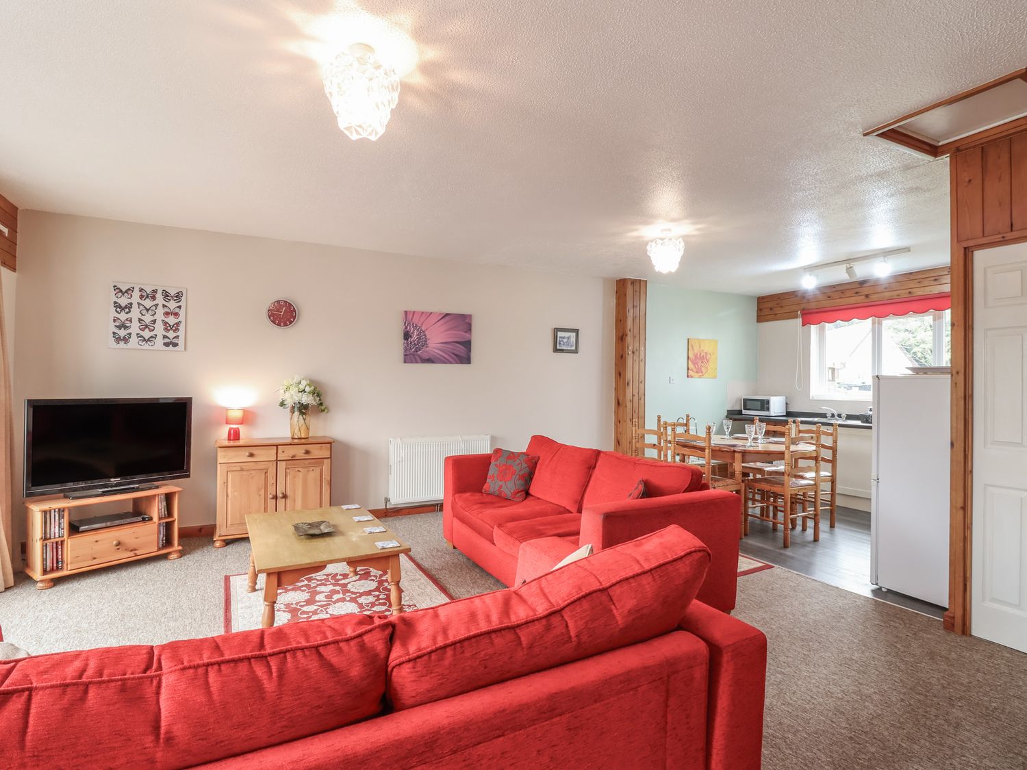 A living room with a television, sofa, and dining area at 21 Tamar & St. Anns Cottages, Honicombe Park near St. Ann's Chapel, Cornwall
