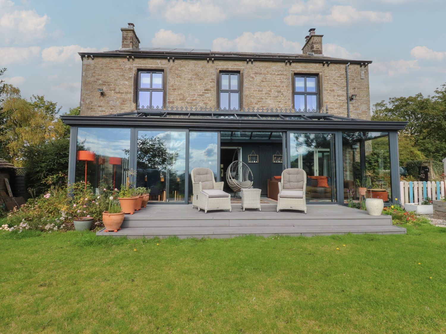 A house with a deck and chairs at Langcliffe House in Kettlewell