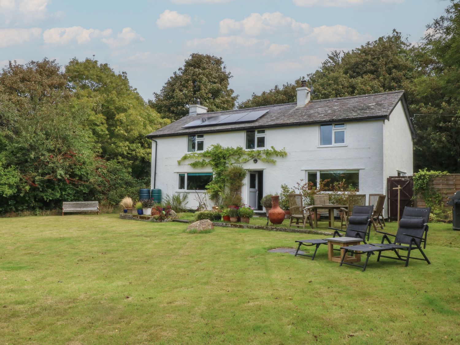 A house with garden furniture and flower pots at Neuadd Wen in Gaerwen