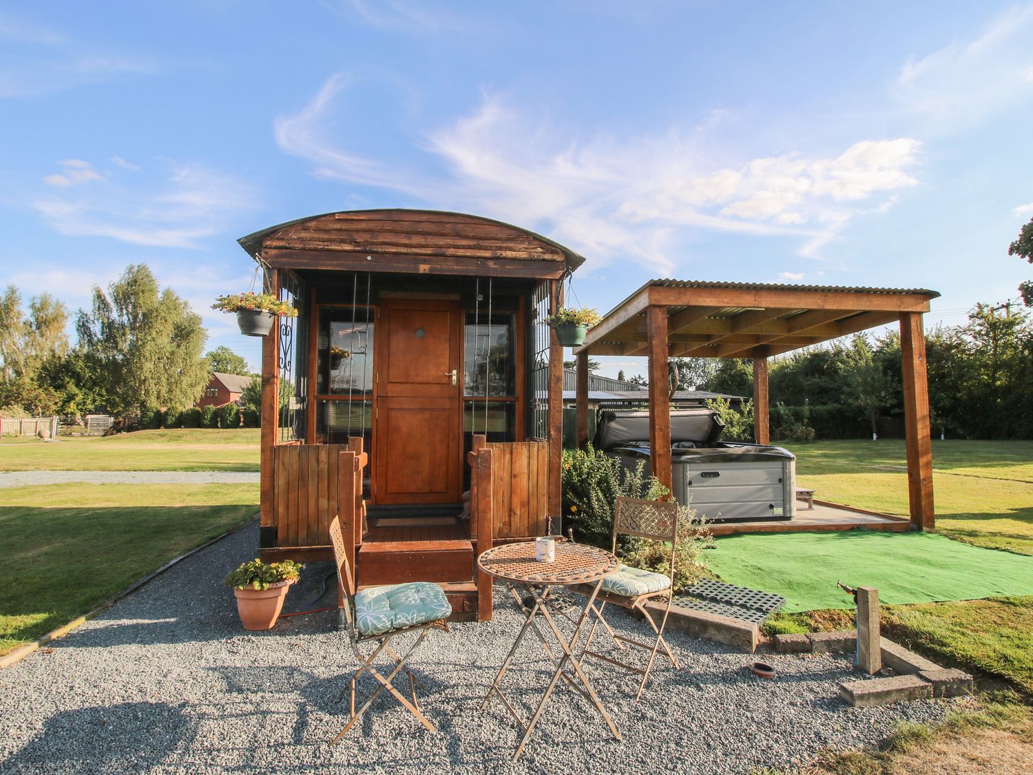 An outdoor area with a shepherd hut and hot tub at Sharon's Shepherd Hut Oswestry