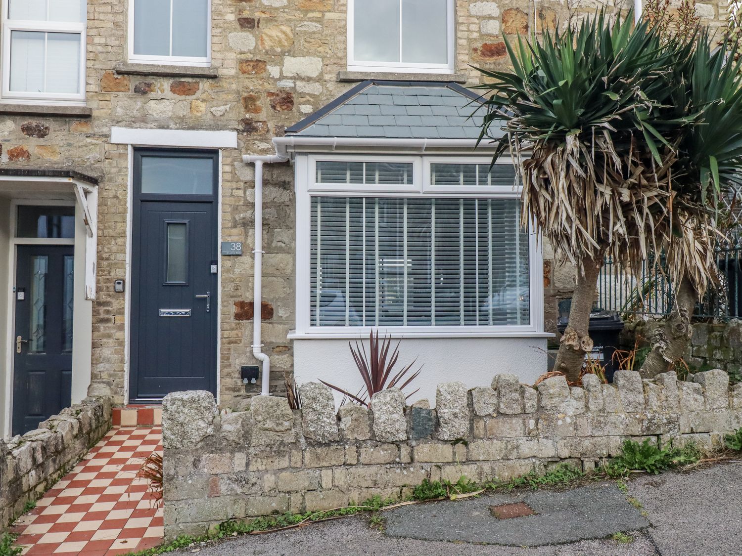 An entrance with a front door and stone wall at Sea Boots in Newquay