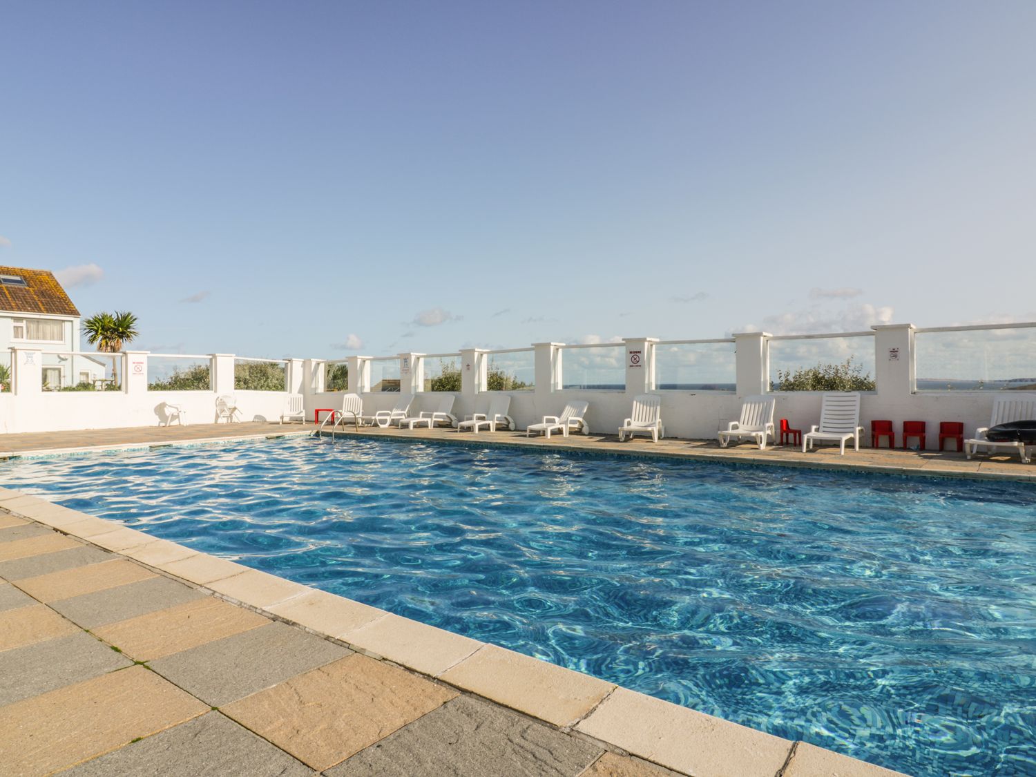 An outdoor swimming pool with chairs at Surf View in Newquay