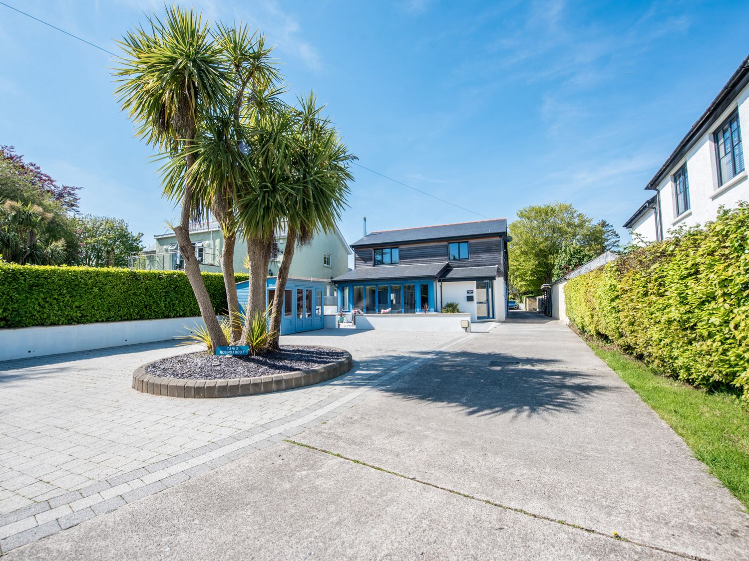 A house with palm trees and a driveway at Sea Haze in Tenby