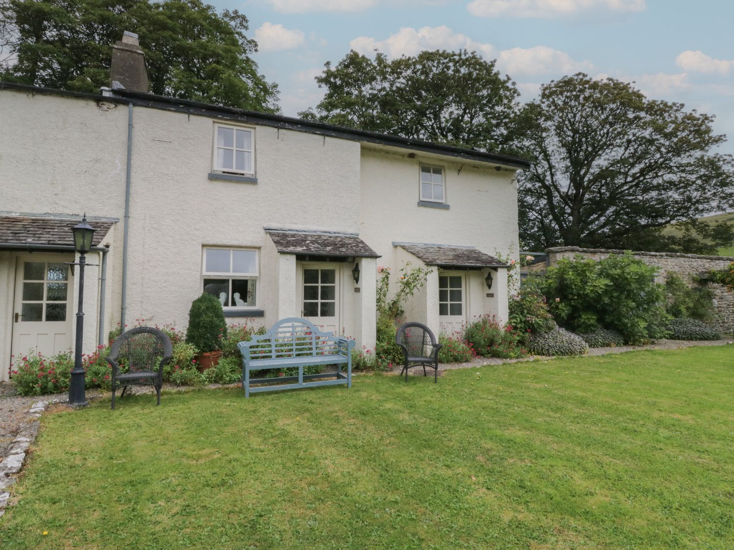 A house with benches and gardens at The Laundrymaid's Cottage in Cartmel