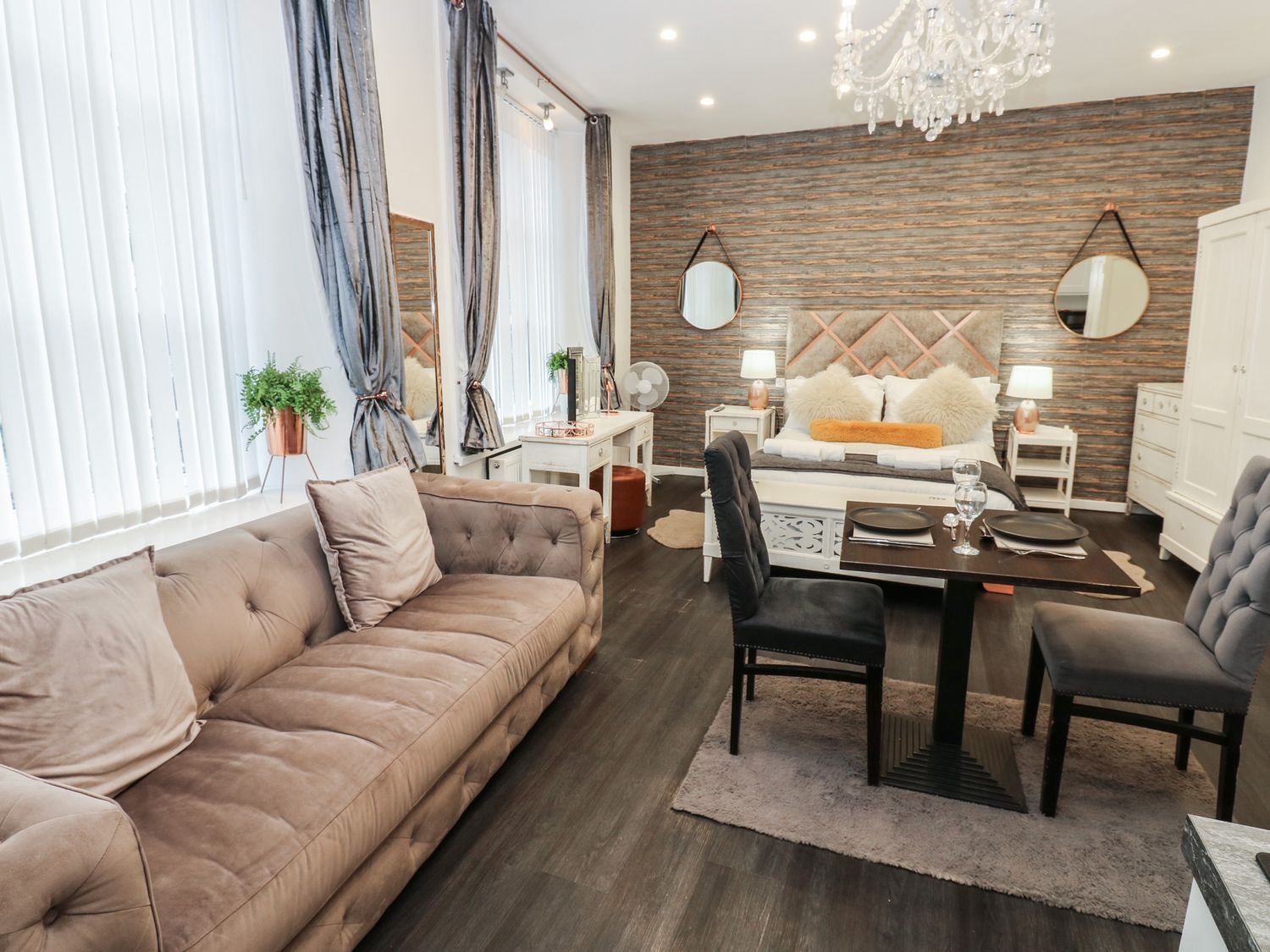 A living room with a sofa, table, and bed at The Railway Apartment in Hexham