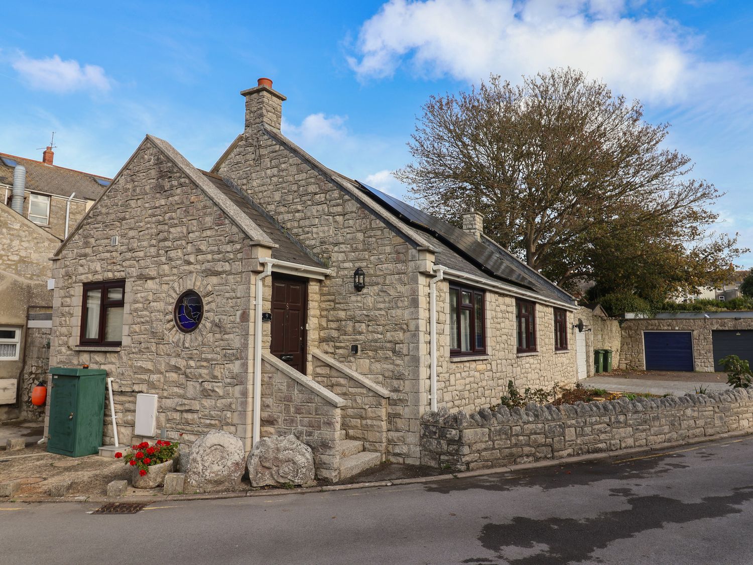 A house with stone exterior and front steps at Arum Portland Bill