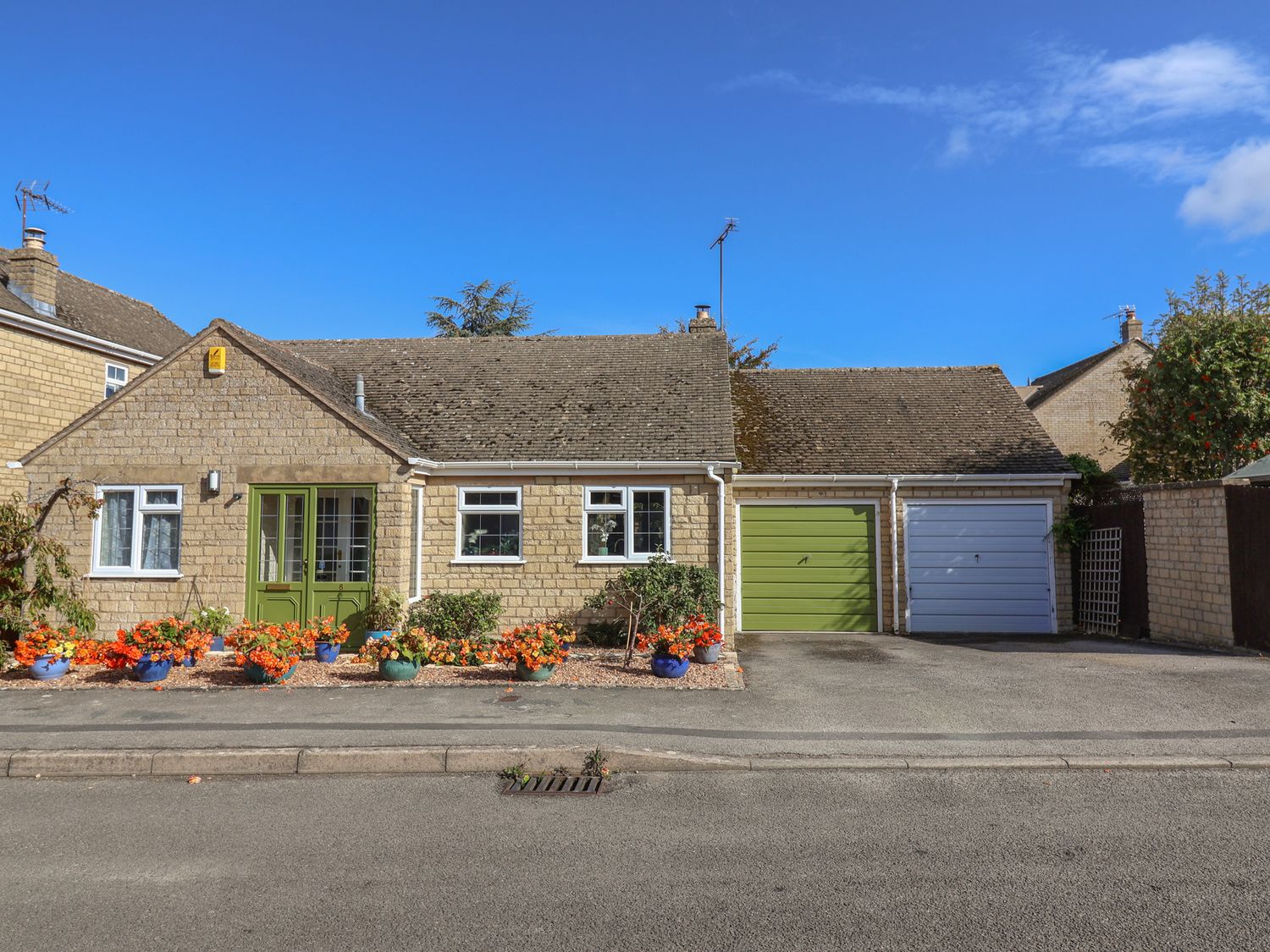 A bungalow with a green door and garages at Evergreen in Broadway