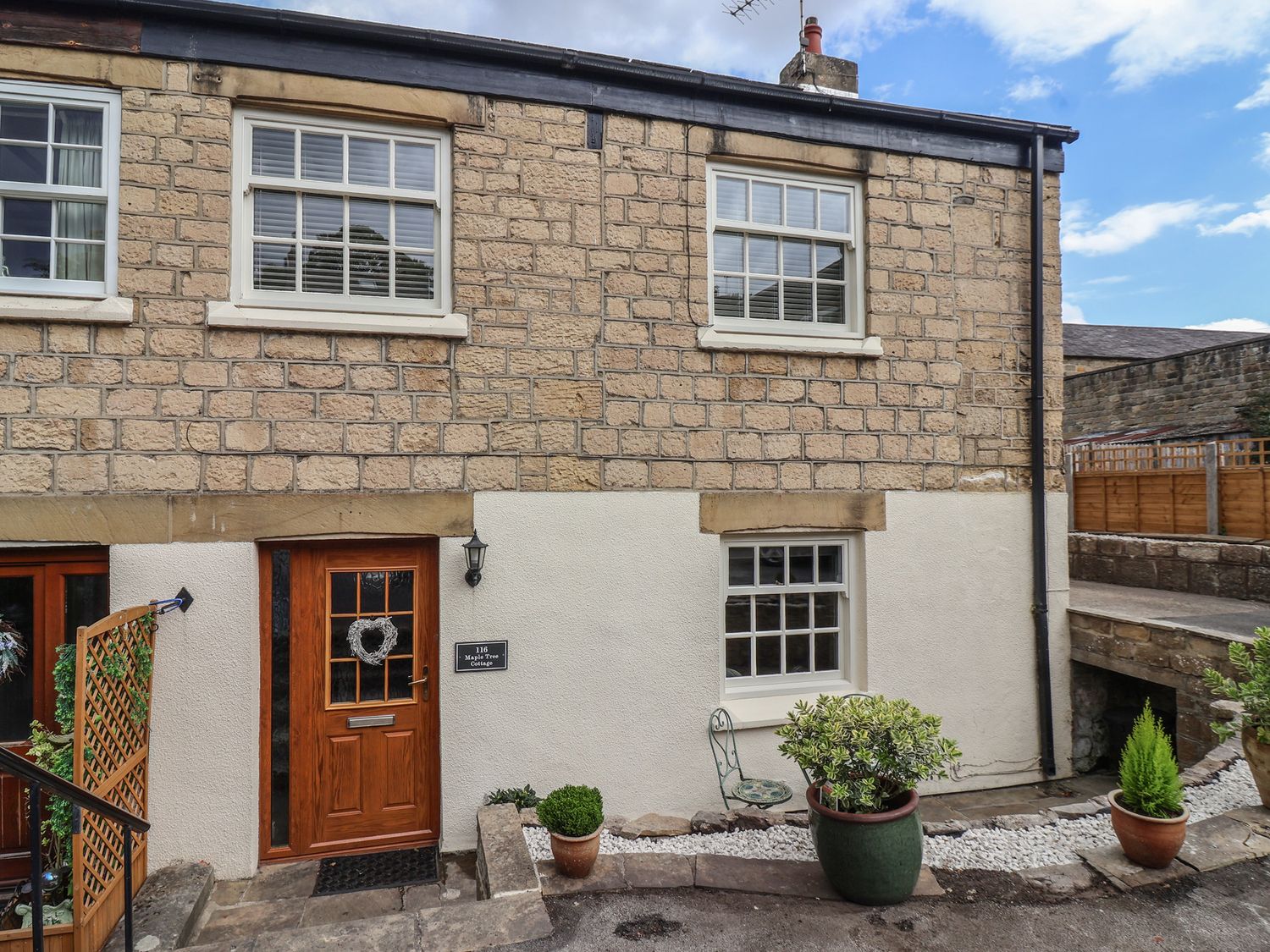 An exterior view of a house with a door and windows at Maple Tree Cottage Knaresborough