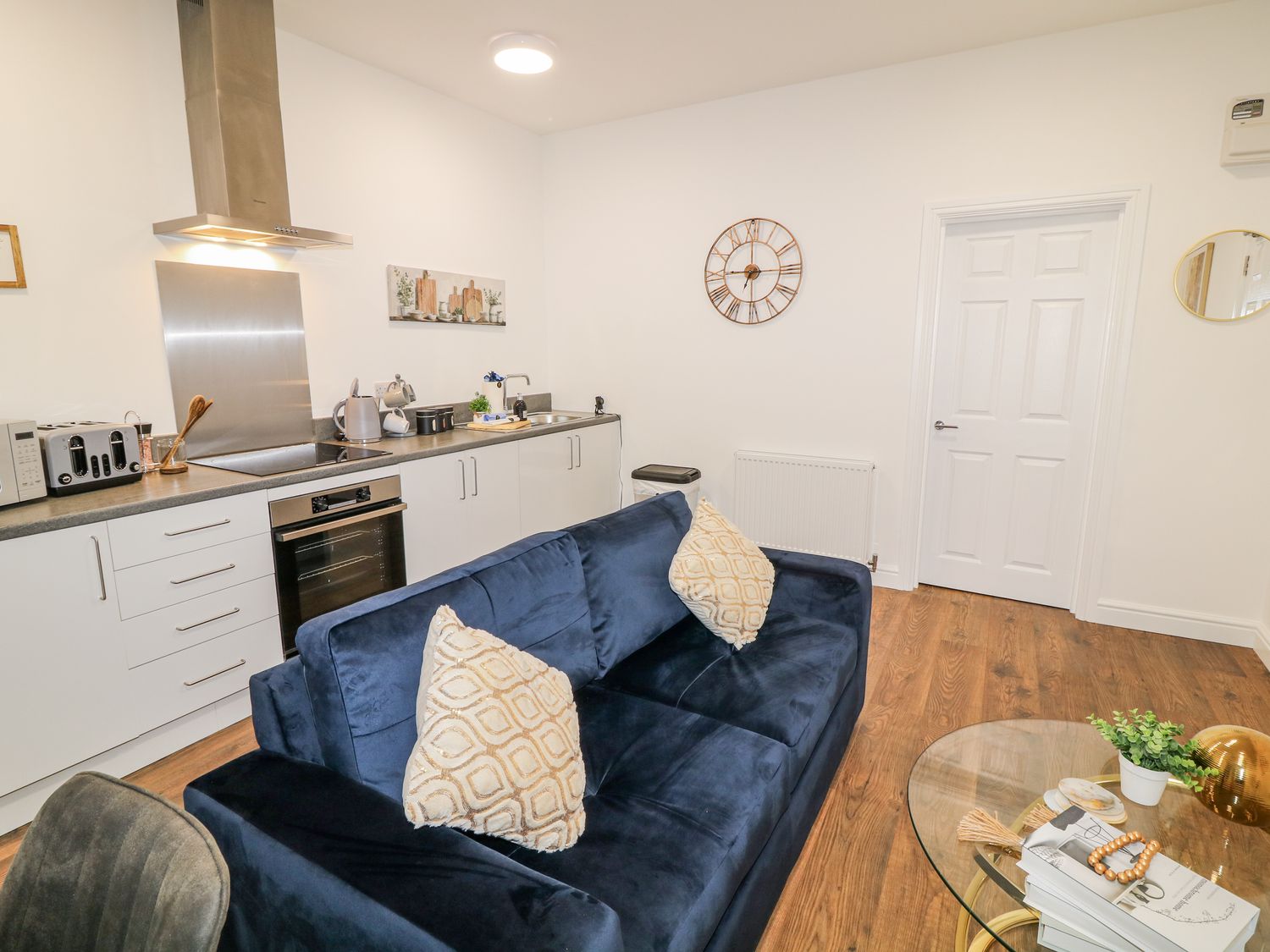 A living room with a sofa and kitchen units at 1 in Peterborough