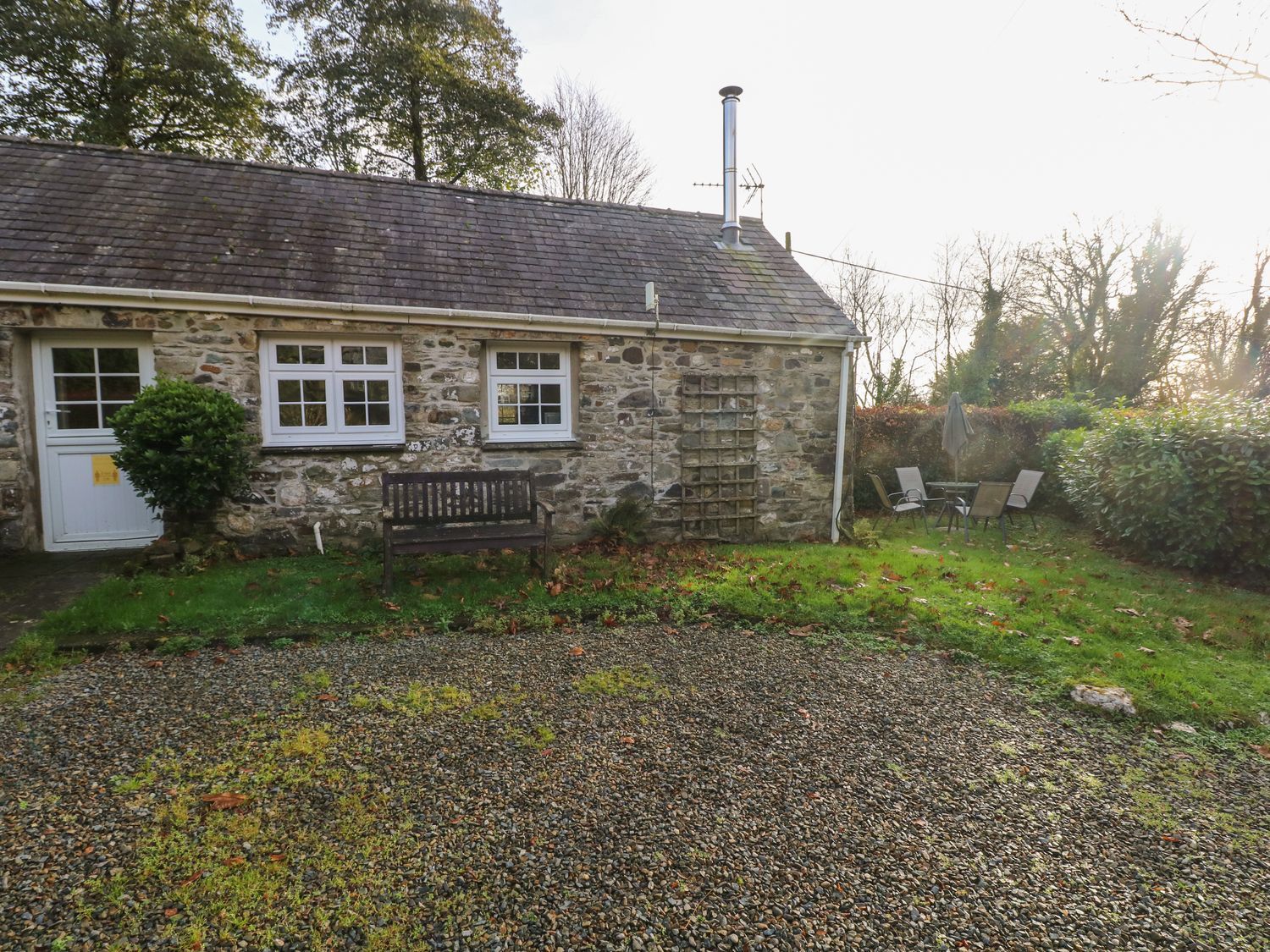 A stone cottage with bench and chairs in the garden at Knap Cottage, Clarbeston Road