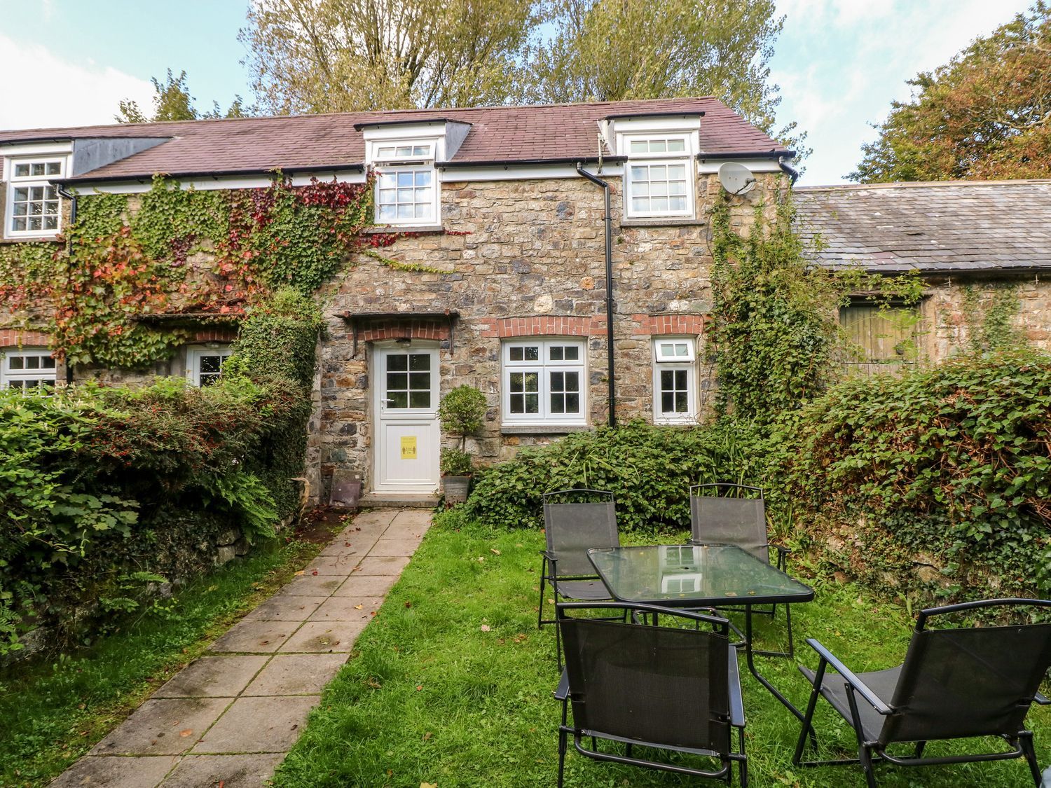 A house with garden furniture and greenery at Swallows Cottage in Clarbeston Road