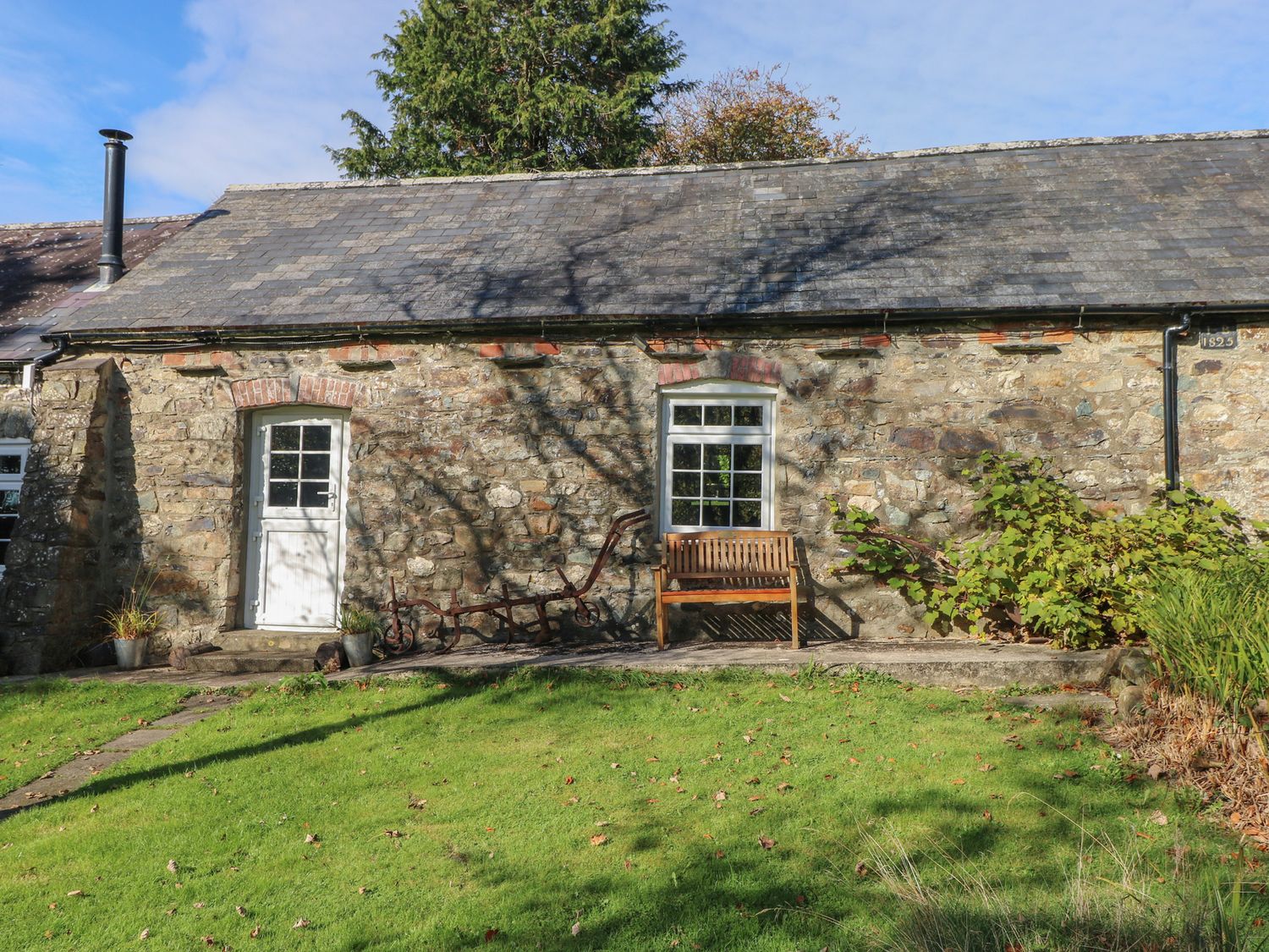 An outdoor view of a cottage with a garden at Granary Cottage in Clarbeston Road