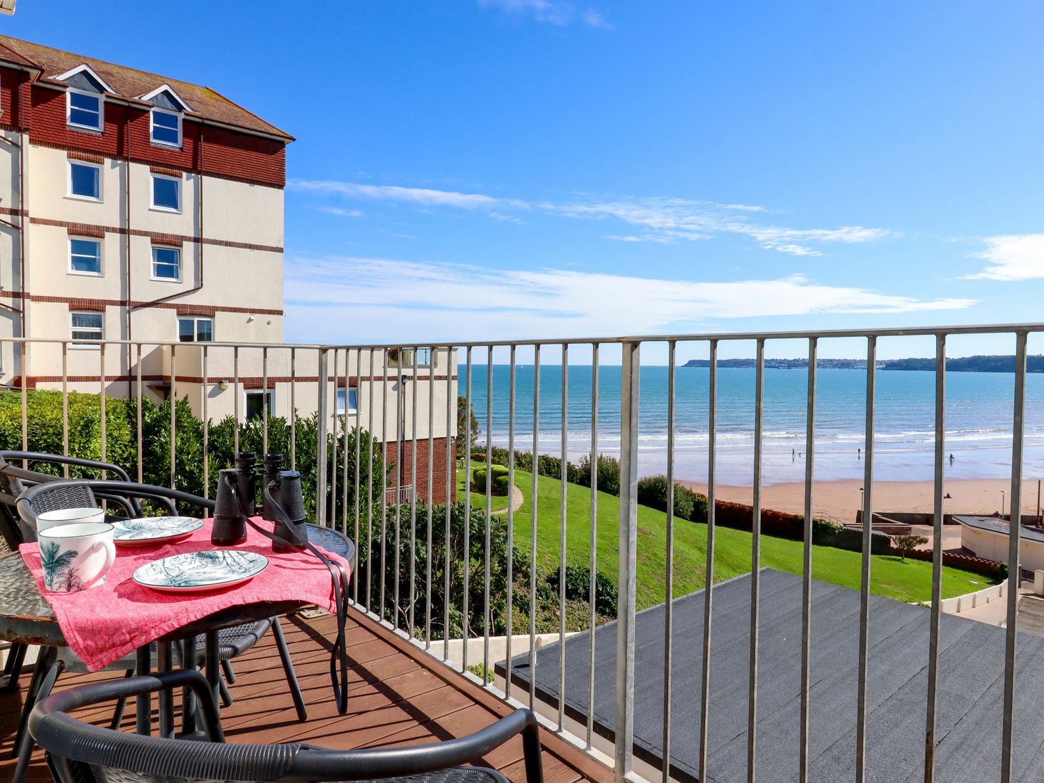 A balcony with a table and chairs overlooking the beach at Beachside