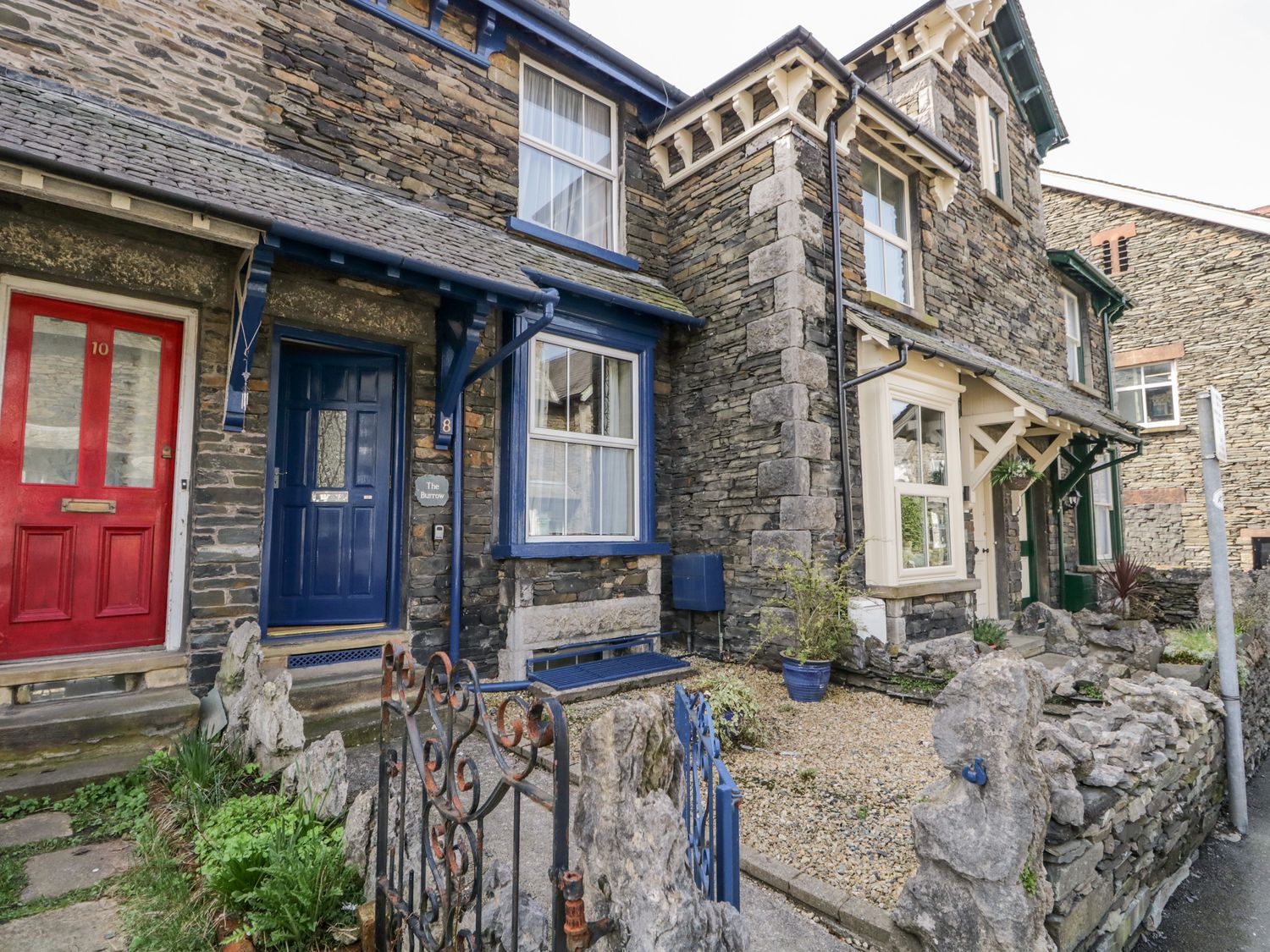 A stone house with red and blue doors at The Burrow in Windermere