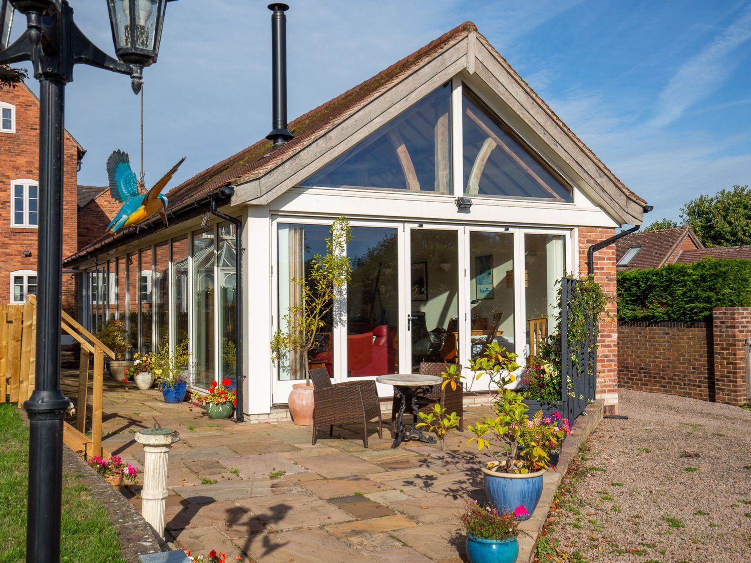 A conservatory with glass walls and plants outside at Nature's Lodge in Kidderminster