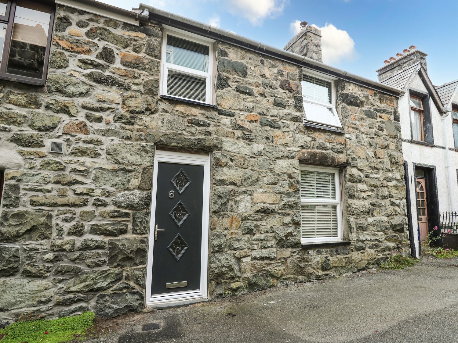 A stone wall with a front door and windows at 6 Upperfield Street in Dolgellau