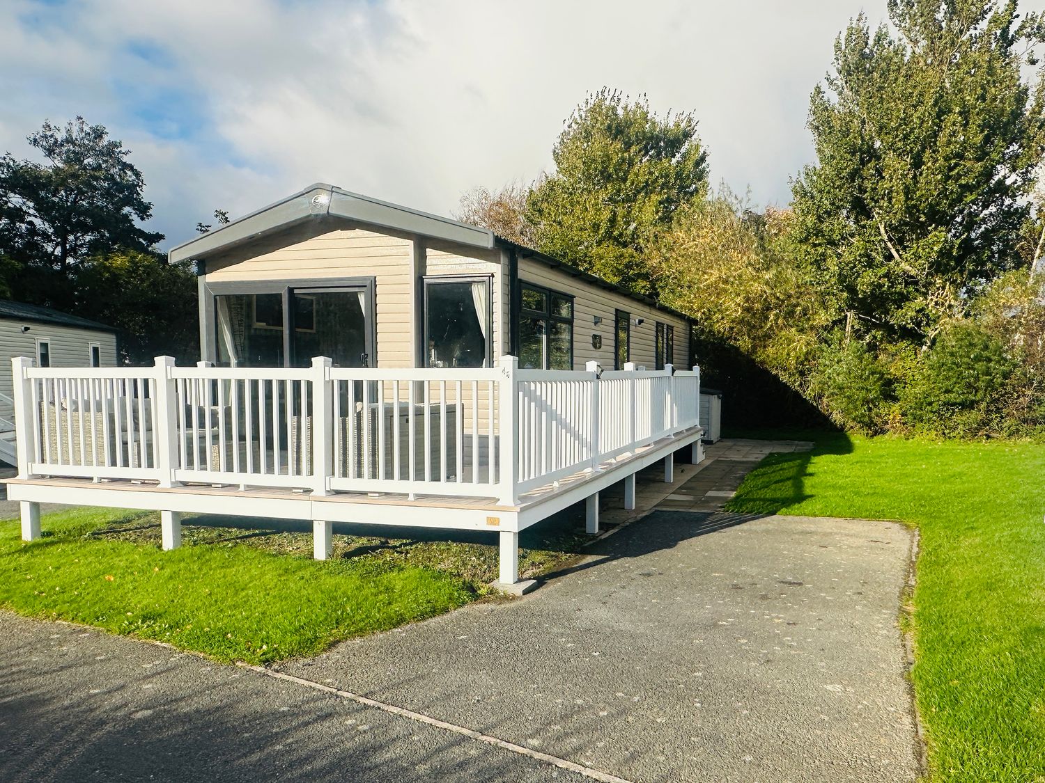 A cabin with a deck and pathway in Hafan y Mor Haven - Holiday Accommodation 13392 Pwllheli
