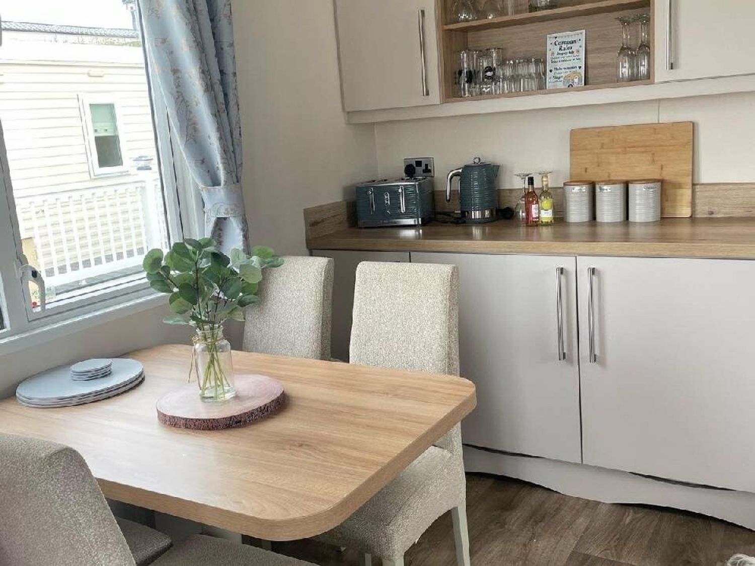 a dining area with a wooden table and chairs near a kitchenette at Quay West Holiday Park - Holiday Accommodation 16905 in New Quay