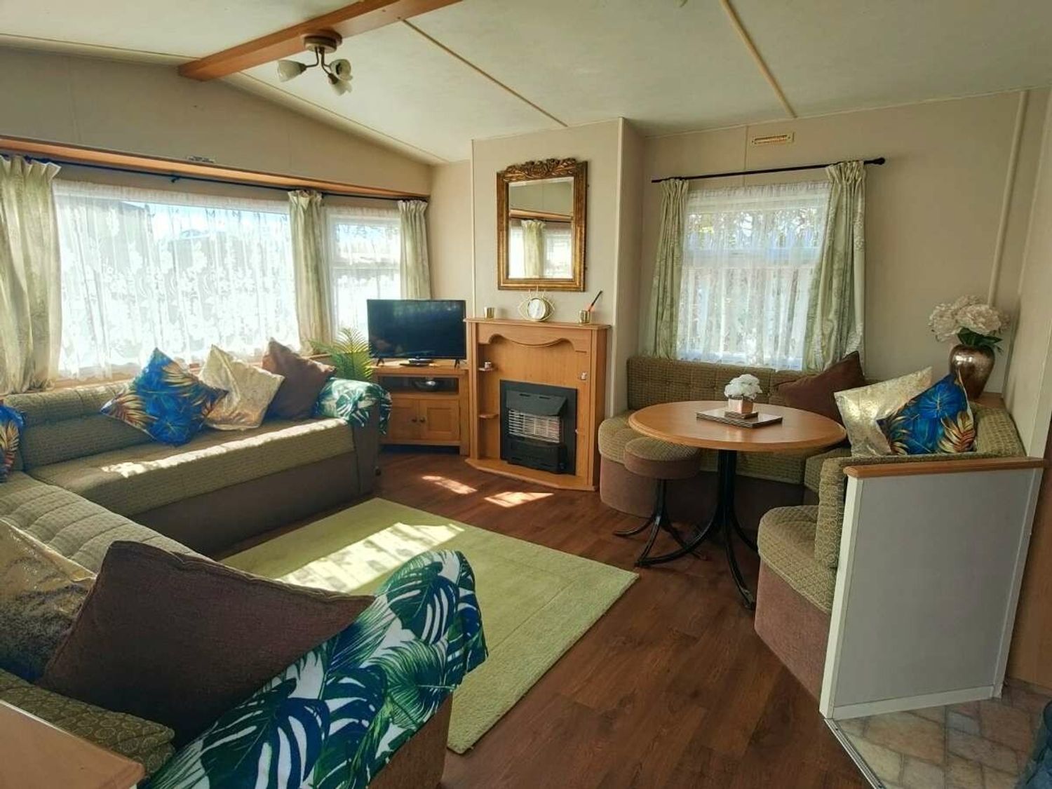 a living room with a TV, sofa, and a round table at Promenade Site - Holiday Accommodation 18601, Ingoldmells
