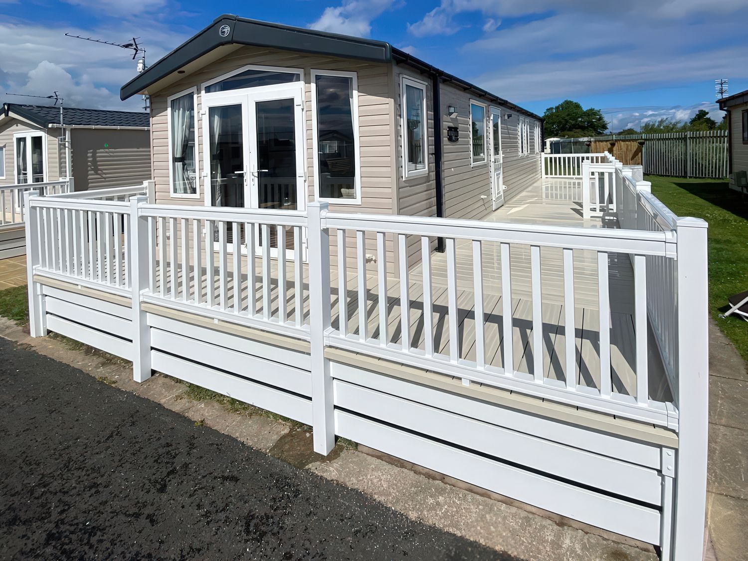 An outdoor area with a holiday home and decking at Marine Holiday Park - Holiday Accommodation 20147, Rhyl