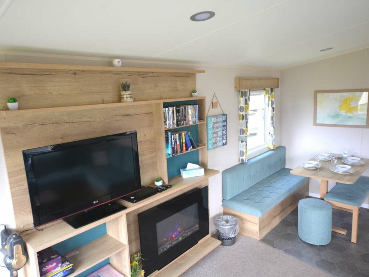 a living area with a television, bookshelves, and a dining table at Perran Sands - Holiday Accommodation 20230 in Perranporth
