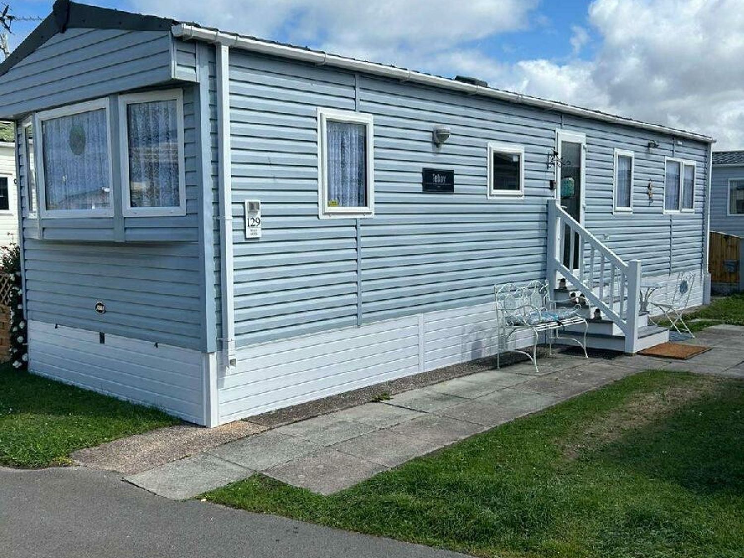 a mobile home with a small porch and patio area at Golden Gate Holiday Centre - Holiday Accommodation 22053 Towyn, Abergele