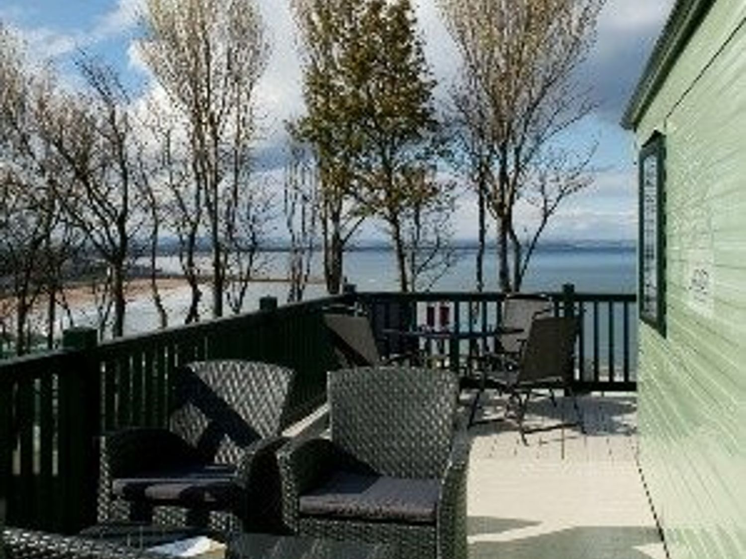a balcony with chairs and a table overlooking a body of water at St Andrews Holiday Park - Holiday Accommodation 2944 St Andrews