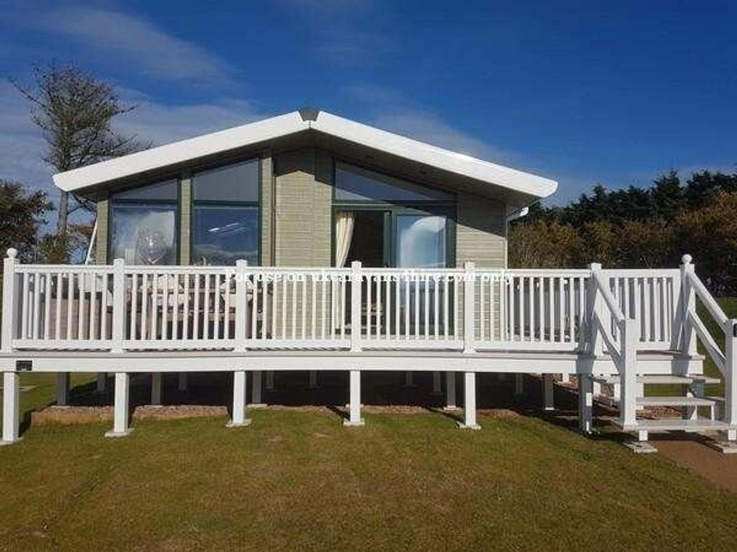 a cabin with a wooden deck and railings at Devon Cliffs Holiday Park - Holiday Accommodation 4101 in Exmouth