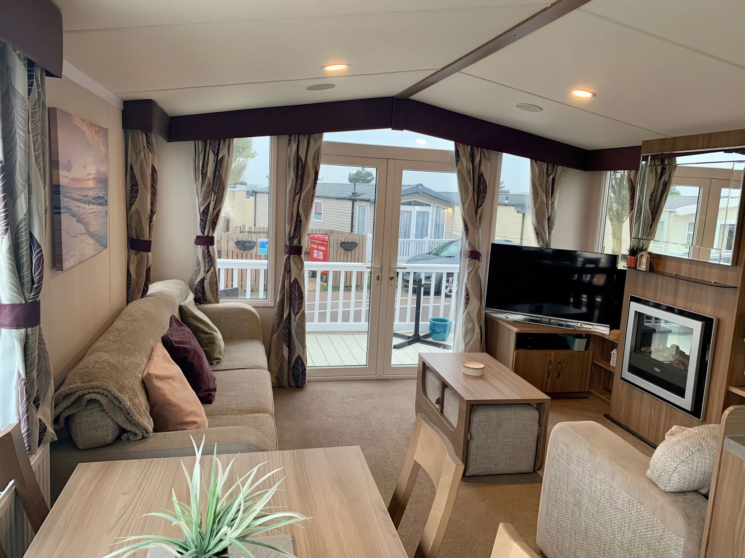 A living room with a sofa and television at Seashore Holiday Park - Holiday Accommodation 848 in Great Yarmouth