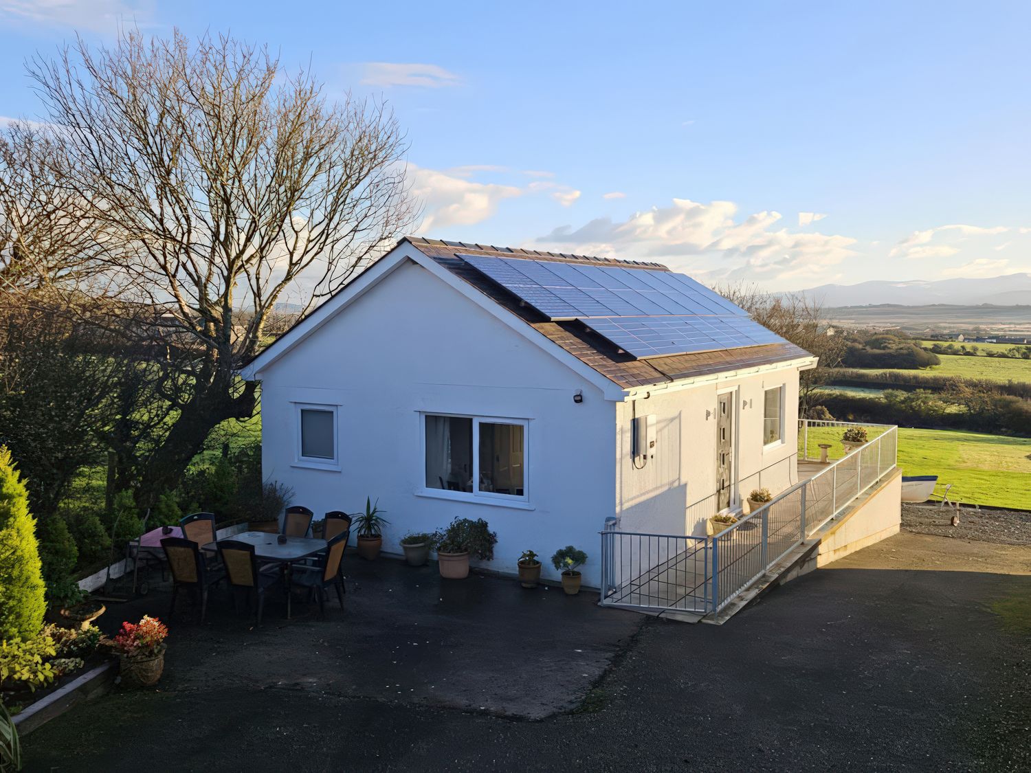 A house with solar panels and outdoor seating area at Ty Nain in Bethel