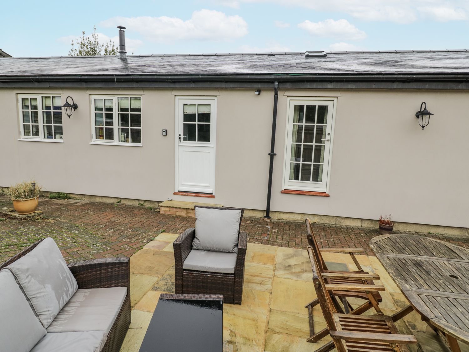 An outdoor lounge area with seating and a table at Rose Stables in Black Bourton near Bampton