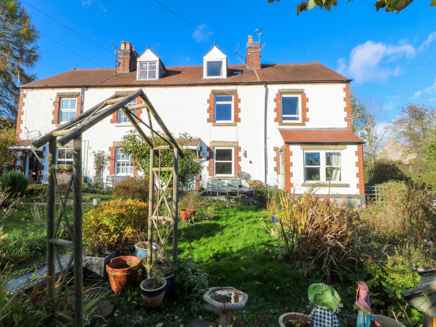 A house with a garden and archway at Pineapple Cottage