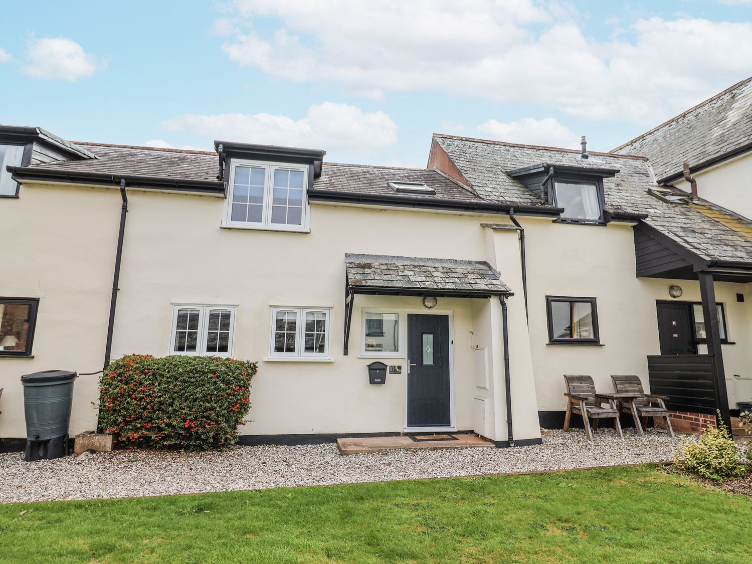 A house with garden and chairs at Rushmoor Cottage in Colaton Raleigh