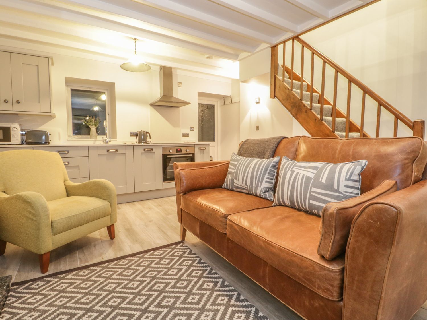 A living room with a sofa and armchair at Riverside Cottage in Conwy