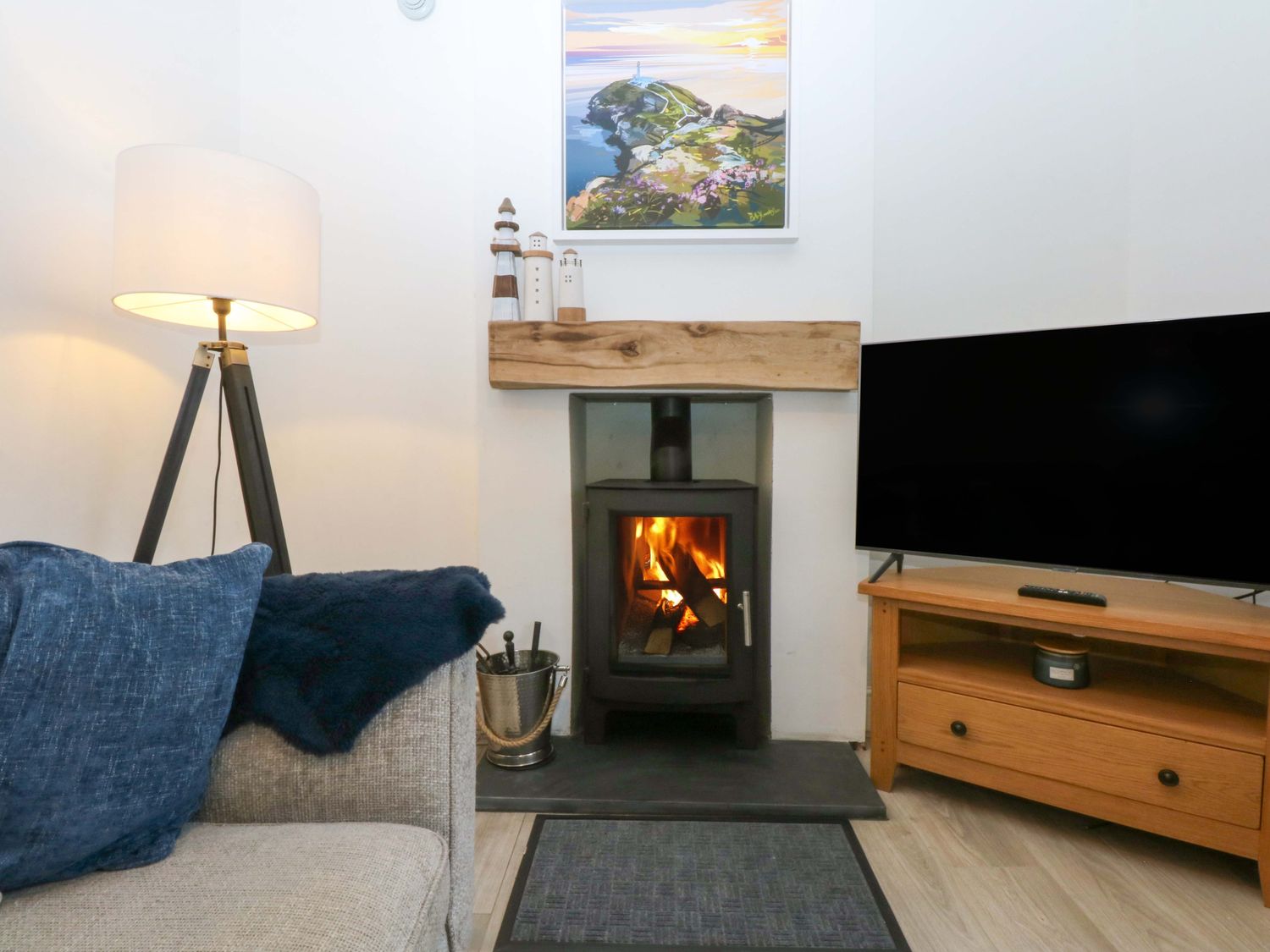 A living room with a fireplace and television at 4 Brynteg Terrace Menai Bridge