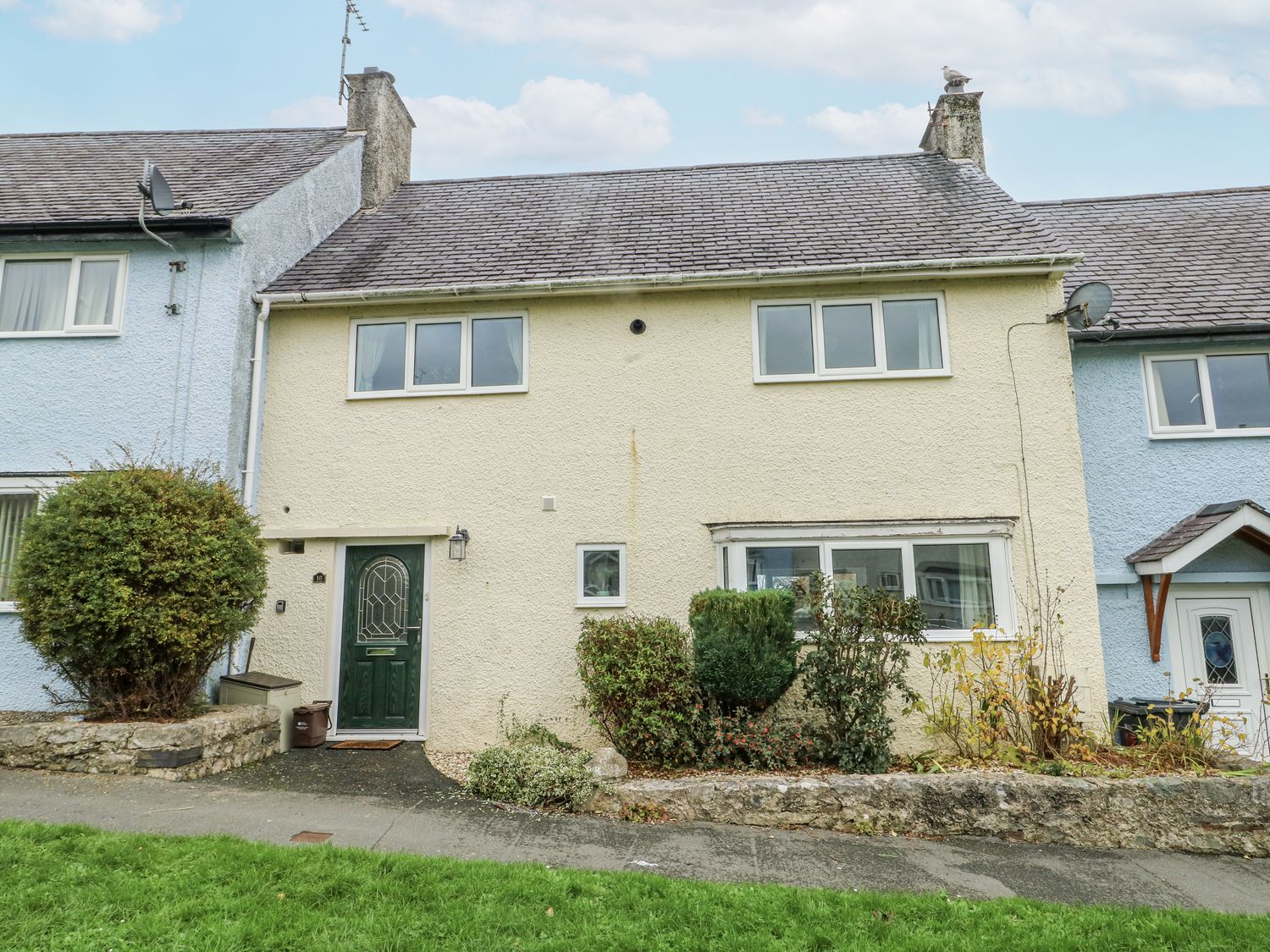 A house with a green door and windows at 16 Ffordd Meigan Beaumaris