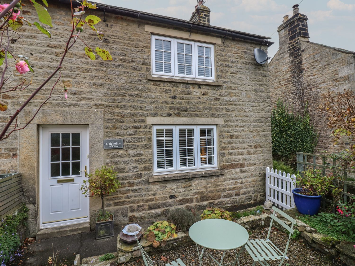 An outdoor view of a stone house with garden furniture at Daleholme in Barnard Castle