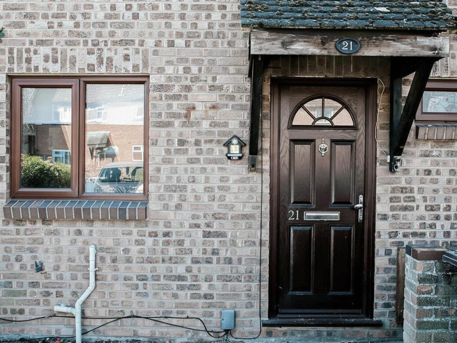 A front door and window on a brick wall at 21
